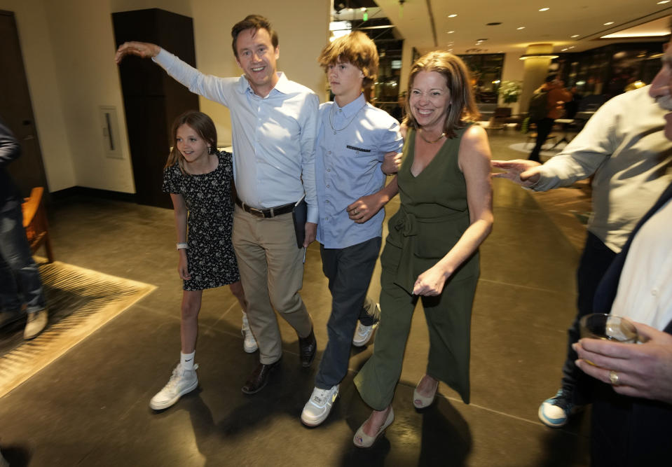 Denver mayoral candidate Mike Johnston, second from left, is flanked by his family while entering an election eve watch party at a hotel late Tuesday, April 4, 2023, in lower downtown Denver. Johnston and Kelly Brough were the top vote-getters in the race, which featured 16 candidates. (AP Photo/David Zalubowski)