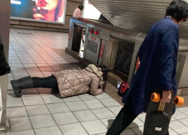 網友捕捉到台北捷運裡，有位女子在地上棒式運動順便視訊的奇景。（翻攝自爆廢公社二館）