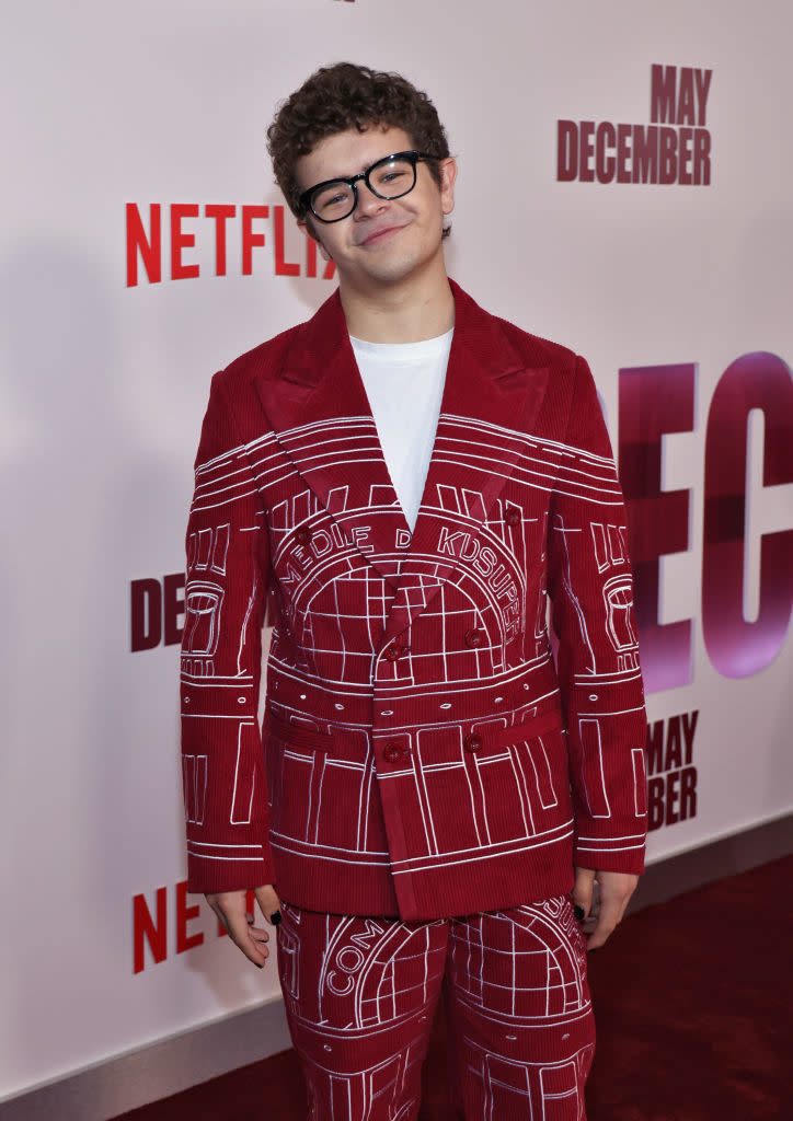 Person poses on red carpet in a patterned red and white outfit