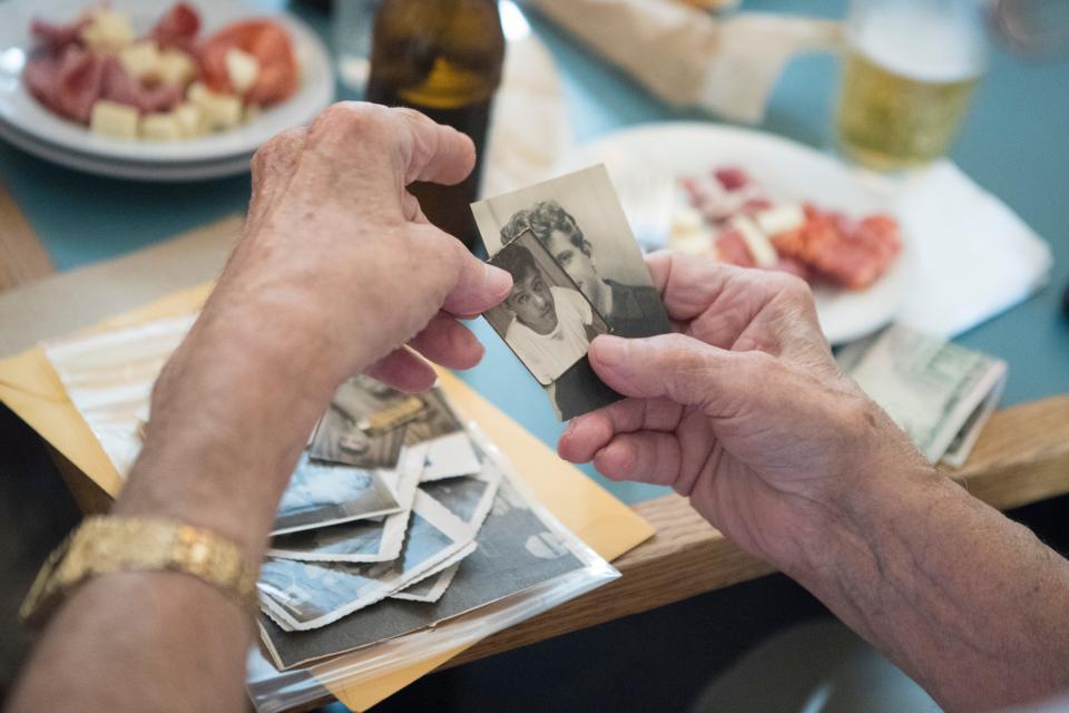 Friends look through old photos during a gathering of former Little Italy residents Thursday, June 16, 2022, at Mrs. Robino's Restaurant.