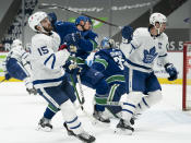 Vancouver Canucks defenseman Nate Schmidt (88) tries to get out of the way of the stick of Toronto Maple Leafs' John Tavares (91), next to Maple Leafs' Alexander Kerfoot (15) during the first period of an NHL hockey game Thursday, March 4, 2021, in Vancouver, British Columbia. (Jonathan Hayward/The Canadian Press via AP)