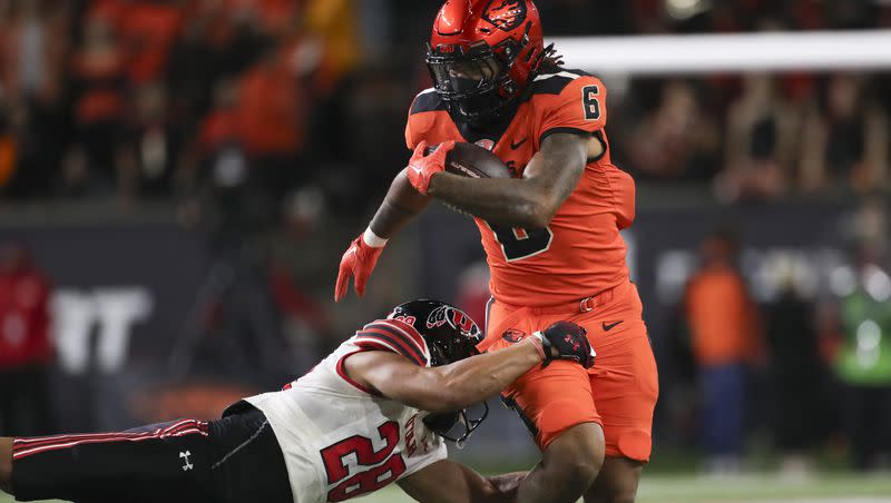 Oregon State running back Damien Martinez is brought down by Utah safety Sione Vaki during game Friday, Sept. 29, 2023, in Corvallis, Ore. Oregon State won 21-7. 