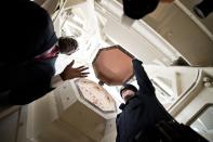 Architect of the Capitol project manager Eugene Poole (L) describes work that will be done to the U.S. Capitol Dome in the coming months as U.S. Capitol Police Officer Adam Taylor (R) holds open one of the coffer windows in the ceiling of the dome during a media tour on Capitol Hill in Washington, December 19, 2013. The dome has not undergone a complete restoration since 1959-1960 and due to age and weather the AOC says that it now has more than 1,000 cracks and deficiencies. Americans longing for a makeover in Washington will get their wish partially granted as the dome of the U.S. Capitol - but not the lawmakers who work inside - undergoes a $60 million restoration. (REUTERS/Douglas Graham/POOL)