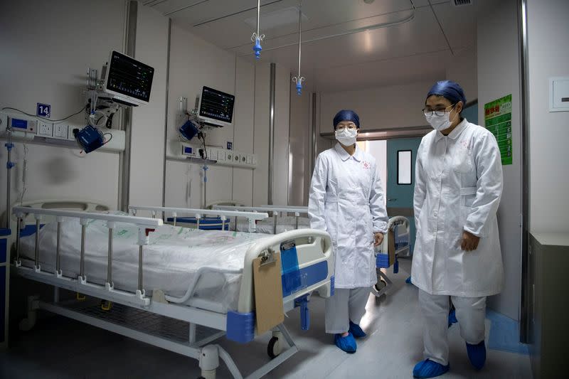 Nurses walk inside a quarantine room for coronavirus patients at finished but still unused building A2 of the Shanghai Public Clinical Center, in Shanghai