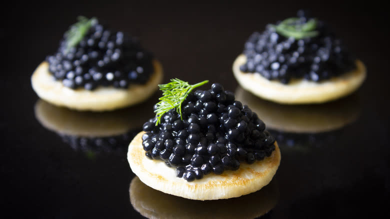 Three black caviar blinis