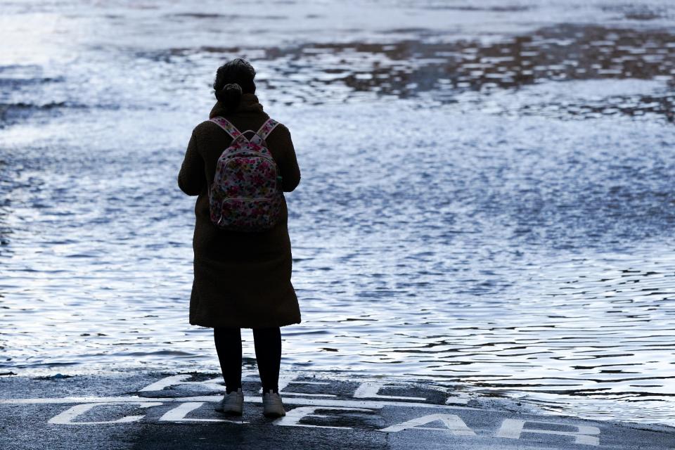 A woman looks out over the River Ouse in York as it floods following rain and melting snow on January 21, 2021 in York, England. (Getty Images)