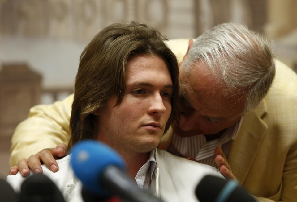 FILE - Raffaele Sollecito listens to his father Francesco Sollecito, right, during a press conference in Rome, Tuesday, July 1, 2014. Amanda Knox returns to an Italian courtroom Wednesday June 5, 2024, for the first time in more than 12½ years to clear herself ‘once and for all’ of a slander charge that stuck even after she was exonerated in the brutal 2007 murder of her British roommate in the idyllic hilltop town of Perugia. (AP Photo/Riccardo De Luca, File)