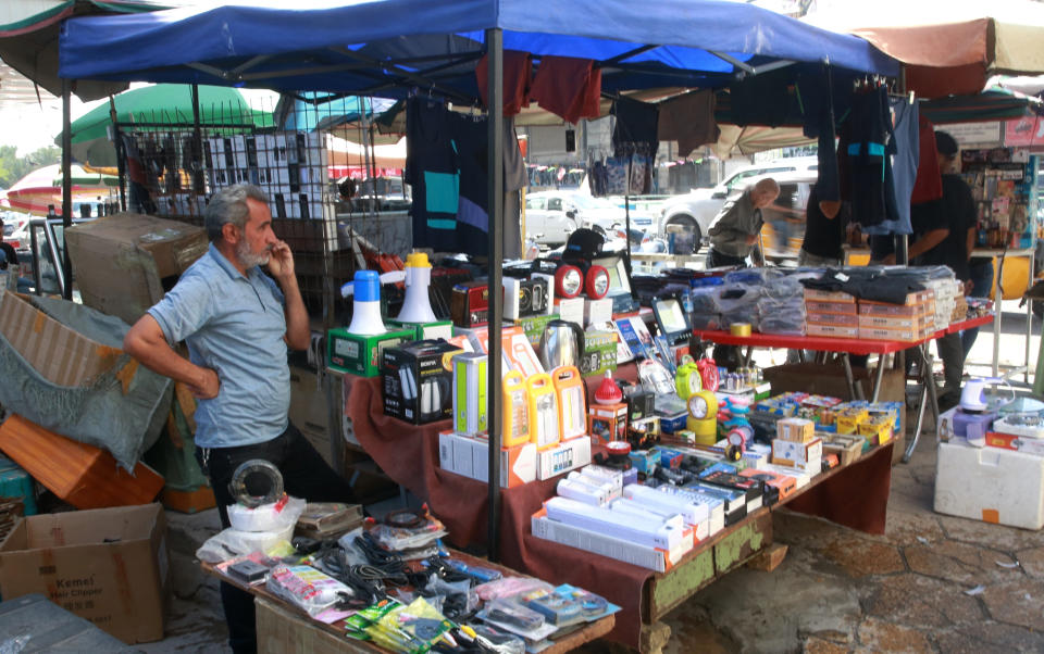 A street vendor waits for customers in Baghdad, Iraq, Tuesday, Oct. 20, 2020. Iraq is in the throes of an unprecedented liquidity crisis, as the cash-strapped state wrestles to pay public sector salaries and import essential goods while oil prices remain dangerously low. (AP Photo/Khalid Mohammed)