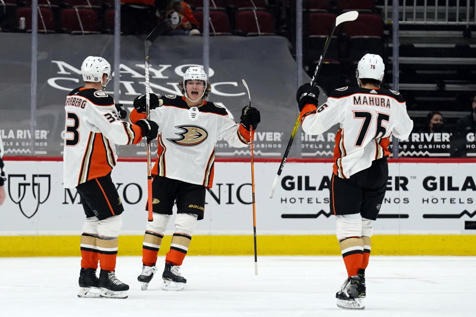 Anaheim Ducks defenseman Josh Mahura (76) celebrates with center Trevor Zegras (46) and right wing Jakob Silfverberg (33) after scoring a goal during the second period of the team's NHL hockey game against the Arizona Coyotes, Wednesday, Feb. 24, 2021, in Glendale, Ariz. (AP Photo/Rick Scuteri)