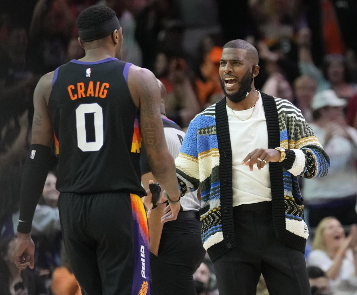 Mar 13, 2022; Phoenix, Arizona, United States;  Phoenix Suns forward Torrey Craig (0) talks with injured guard Chris Paul during the first quarter against the Los Angeles Lakers at Footprint Center.