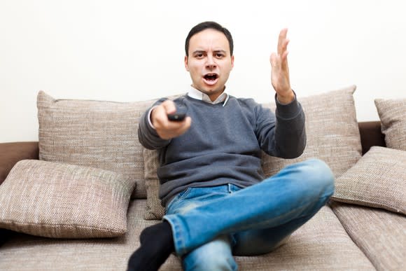 A man appears to be angry at his television.