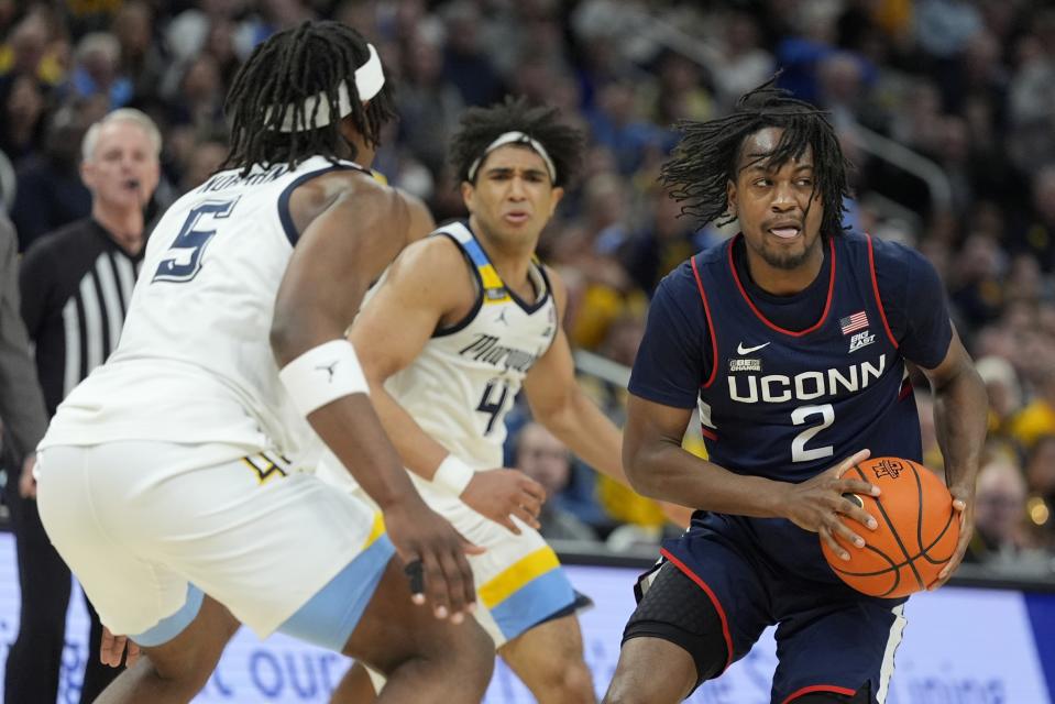 UConn's Tristen Newton looks to get past Marquette's Tre Norman and Stevie Mitchell during the second half of an NCAA college basketball game Wednesday, March 6, 2024, in Milwaukee. UConn won 74-67. (AP Photo/Morry Gash)