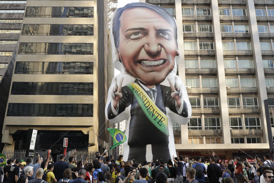 Supporters of Jair Bolsonaro, presidential candidate for the National Social Liberal Party who was stabbed during a campaign event days ago, exhibit a large, inflatable doll in his image as they march along Paulista Avenue to show support for him in Sao Paulo, Brazil, Sunday, Sept. 9, 2018. Brazil will hold general elections on Oct. 7. (AP Photo/Andre Penner)