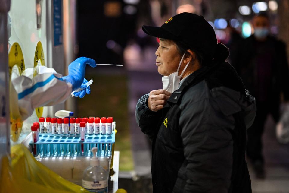 A health worker takes a swab sample from a woman to test for the Covid-19 coronavirus in the Huangpu district in Shanghai on December 19, 2022.