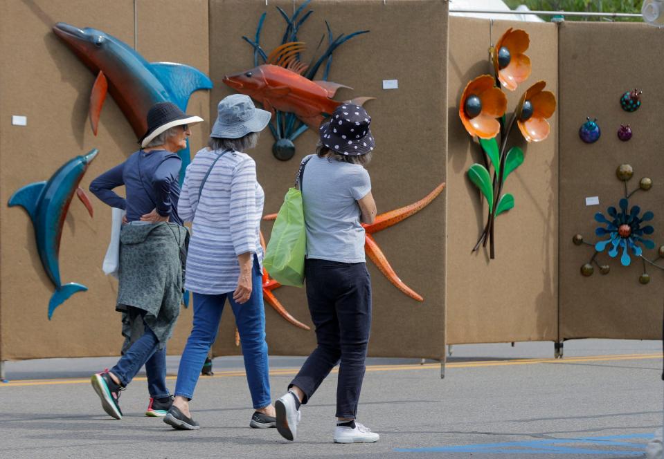 People walk and browse the many works of art for sale during Arts Beats & Eats in downtown Royal Oak on September 3, 2021.