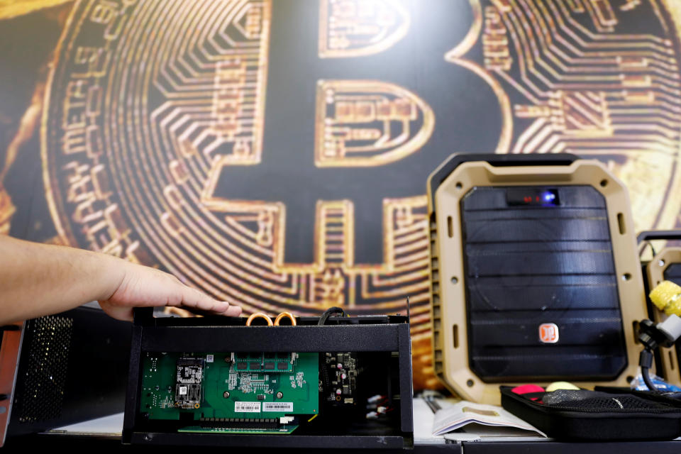 A cryptocurrency mining computer is seen in front of bitcoin logo during the annual Computex computer exhibition in Taipei, Taiwan June 5, 2018. REUTERS/Tyrone Siu
