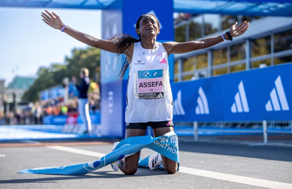 Ethiopia's Tigst Assefa celebrates after crossing the finish line to win the Berlin Marathon.