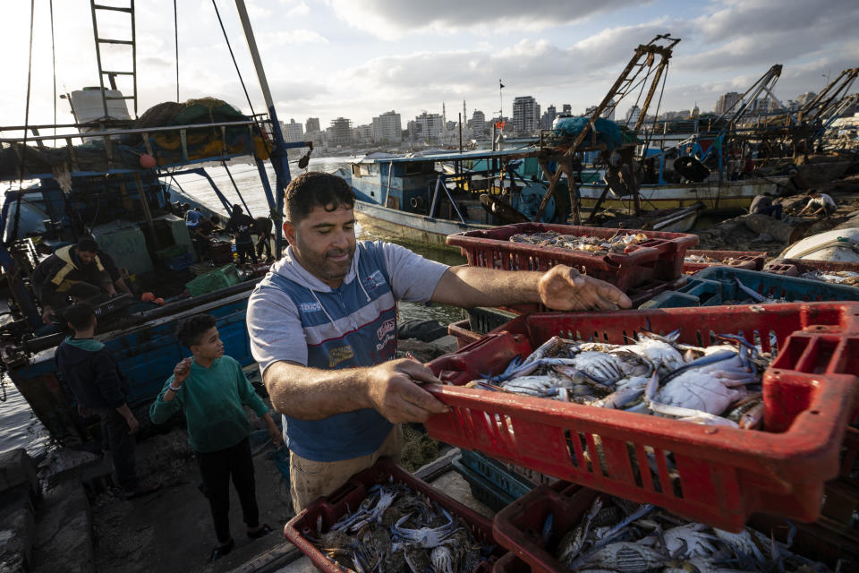 Fisherman load a horse-drawn cart before delivering their haul to market after a limited number of boats were allowed to return to the sea following a cease-fire reached after an 11-day war between Hamas and Israel, in Gaza City, Sunday, May 23, 2021. (AP Photo/John Minchillo)