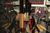 A woman buys bread in the Istanbul Municipality's bread kiosk in Istanbul, Thursday, Dec. 2, 2021. Turkey’s beleaguered currency has been plunging to all-time lows against the U.S. dollar and the euro in recent months as President Recep Tayyip Erdogan presses ahead with a widely criticized effort to cut interest rates despite surging consumer prices. (AP Photo/Emrah Gurel)