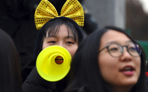 High school students cheer their seniors taking the annual College Scholastic Ability Test, a standardised exam for college entrance, at a high school in Seoul on November 23, 2017 - Credit: JUNG YEON-JE/AFP