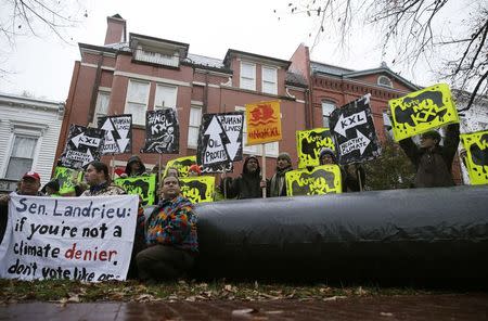 Climate advocates and representatives from the Rosebud Sioux Tribe in South Dakota protest against the Keystone XL pipeline in front of the home (center) of U.S. Senator Mary Landrieu (D-LA), chair of the Senate Energy Committee, in Washington November 17, 2014. REUTERS/Gary Cameron
