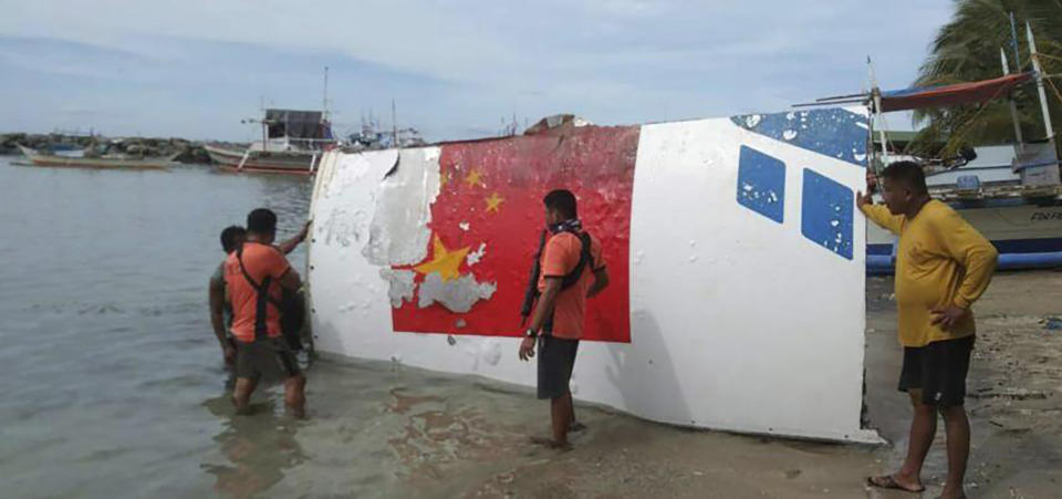 In this handout photo provided by the Philippine Coast Guard, rescuers recover debris, which the Philippine Space Agency said has markings of the Long March 5B (CZ-5B) Chinese rocket that was launched on July 24, after it was found in waters off Mamburao, Occidental Mindoro province, Philippines, on Aug. 2, 2022. In July, the core stage debris of the Long March 5B rocket that was launched in China landed in Philippine waters in an uncontrolled reentry, the agency said. No damage or injuries were reported. (Philippine Coast Guard via AP)