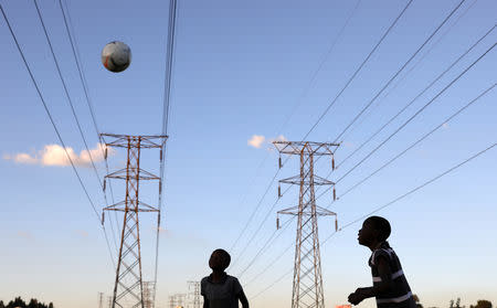 Boys play soccer below electricity pylons in Soweto, South Africa, February 20, 2019. REUTERS/Siphiwe Sibeko