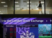 LONDON, ENGLAND - AUGUST 05: A worker walks past screens showing stock market price falls at The London Stock Exchange on August 5, 2011 in London, England. The Eurozone debt crisis has caused further falls in stock markets around the world. (Photo by Peter Macdiarmid/Getty Images)