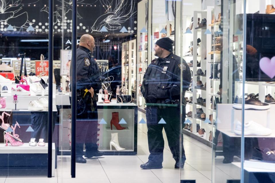 A pair of NYPD officers make their rounds and stop by the Adol store on 42nd Street, which has been robbed several times by criminals. Aristide Economopoulos