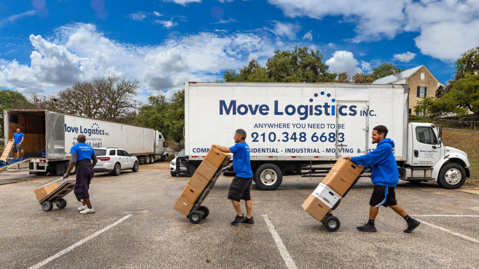 The Move Logistics Inc. team using dollies in front of a company truck