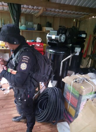 An agent of the Guatemalan National Civil Police (PNC) is pictured during an operation to dismantle a coca processing lab in Izabal