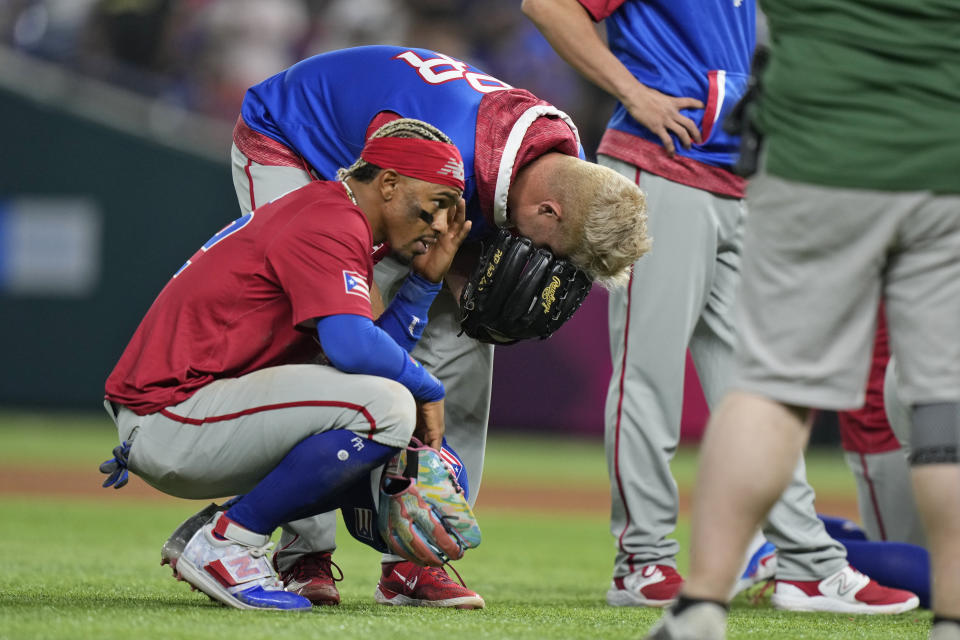 Puerto Rico players react after pitcher Edwin Diaz appeared to be injured during postgame celebration after Puerto Rico beat the Dominican Republic 5-2 during a World Baseball Classic game, Wednesday, March 15, 2023, in Miami. (AP Photo/Wilfredo Lee)