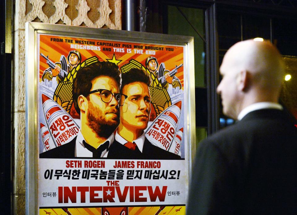 A security guard stands at the entrance of United Artists theater during the premiere of the film "The Interview" in Los Angeles, California in this December 11, 2014 file photo. The New York premiere of "The Interview", a Sony Pictures comedy about the assassination of North Korean President Kim Jong-Un, has been canceled and a source said one theatre chain had scrapped plans to show it, after threats from a hacking group. REUTERS/Kevork Djansezian/Files (UNITED STATES - Tags: ENTERTAINMENT)