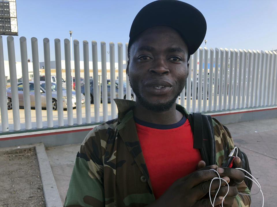 Ngoh Elliot Takere gives an interview in Tijuana, Mexico, where he has been waiting for two months to apply for asylum in the U.S., Thursday, Sept. 12, 2019, on the border with San Diego. Takere left his war-torn Cameroon after being jailed by police for being part of the English speaking minority; paid $400 bail and was released on the condition that he leave the country or the French speaking government would track him down and kill him, he said. (AP Photo/Julie Watson)