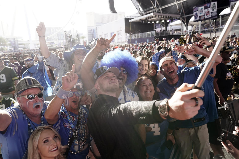 Michigan defensive end Aidan Hutchinson takes photos with fans after being selected by the Detroit Lions as the second pick in the NFL football draft Thursday, April 28, 2022, in Las Vegas. (AP Photo/Jae C. Hong)