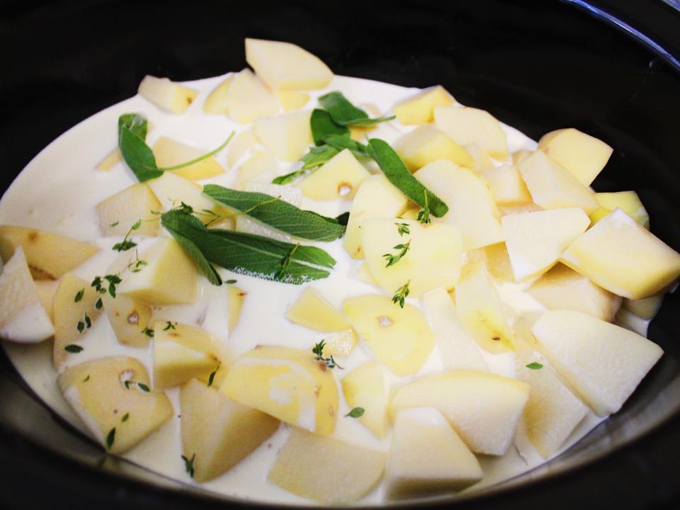 chopped potatoes, herbs, and cream in slow cooker
