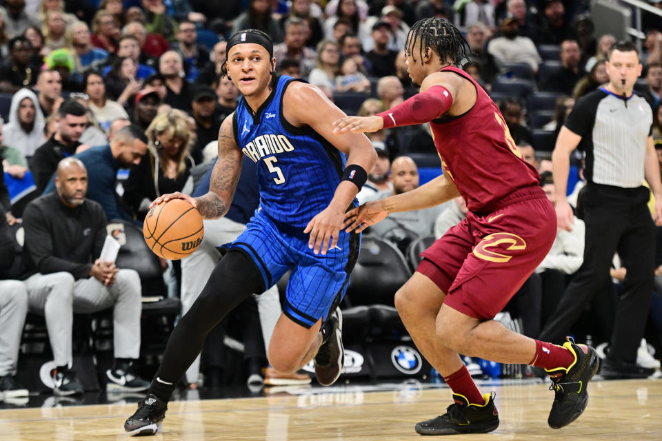 ORLANDO, FLORIDA - DECEMBER 11: Paolo Banchero #5 of the Orlando Magic drives to the net against Isaac Okoro #35 of the Cleveland Cavaliers in the second half of a game at Amway Center on December 11, 2023 in Orlando, Florida. NOTE TO USER: User expressly acknowledges and agrees that, by downloading and or using this photograph, User is consenting to the terms and conditions of the Getty Images License Agreement. (Photo by Julio Aguilar/Getty Images)