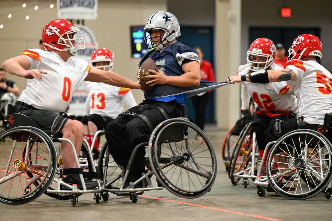 Dallas Cowboys player Jason Rainey (7) is tackled by Kansas City Chiefs player Clayton Peters (0) and Kansas City Chiefs player Jason Lofts (58) during the USA Wheelchair Football League Championship, a program of Move United, Tuesday, Feb. 6, 2024 in Dallas, Texas. Reed Hoffmann/Move United