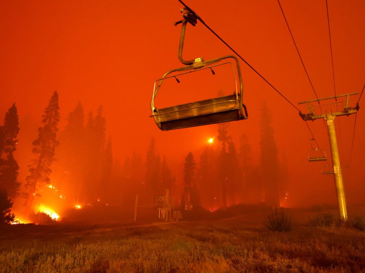 An empty chairlift near Lake Tahoe as the Caldor fire burns in the background