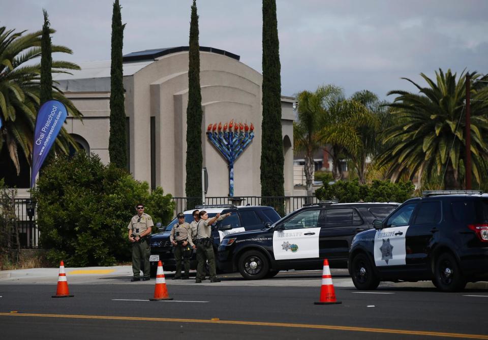 Sheriff's deputies stand near a street outside a synagogue.