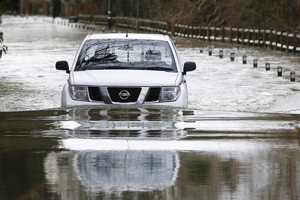 A car drives through a flooded road in Shepperton, England, Tuesday, Feb. 11, 2014. The River Thames has burst its banks after reaching its highest level in years, flooding riverside towns upstream of London. The River Thames has burst its banks after reaching its highest level in years, flooding riverside towns upstream of London. Residents and British troops piled up sandbags to protect properties from the latest bout of flooding, but the river overwhelmed their defenses in several places Monday, leaving areas underwater. (AP Photo/Sang Tan)