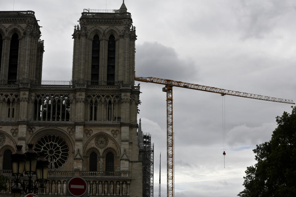 A crane stands by Notre Dame Cathedral, Friday, July 10, 2020 in Paris. Notre Dame Cathedral will be rebuilt just the way it stood before last year's devastating fire. (AP Photo/Thibault Camus)