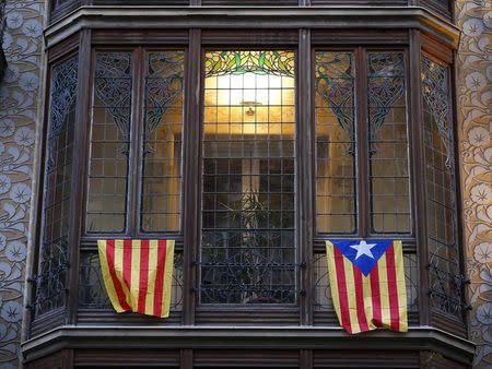 A pro-Catalan independence flag (R) known as the "Estelada" hangs from a balcony in central Barcelona as Catalonia participates in a symbolic independence vote November 9, 2014. REUTERS/Paul Hanna