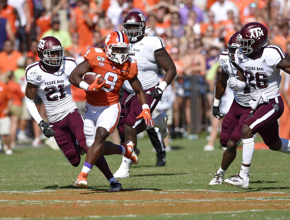 Clemson's Travis Etienne (9) rushes while defended by Texas A&M's Charles Oliver (21) and Demani Richardson (26) during the first half of an NCAA college football game Saturday, Sept. 7, 2019, in Clemson, S.C. (AP Photo/Richard Shiro)