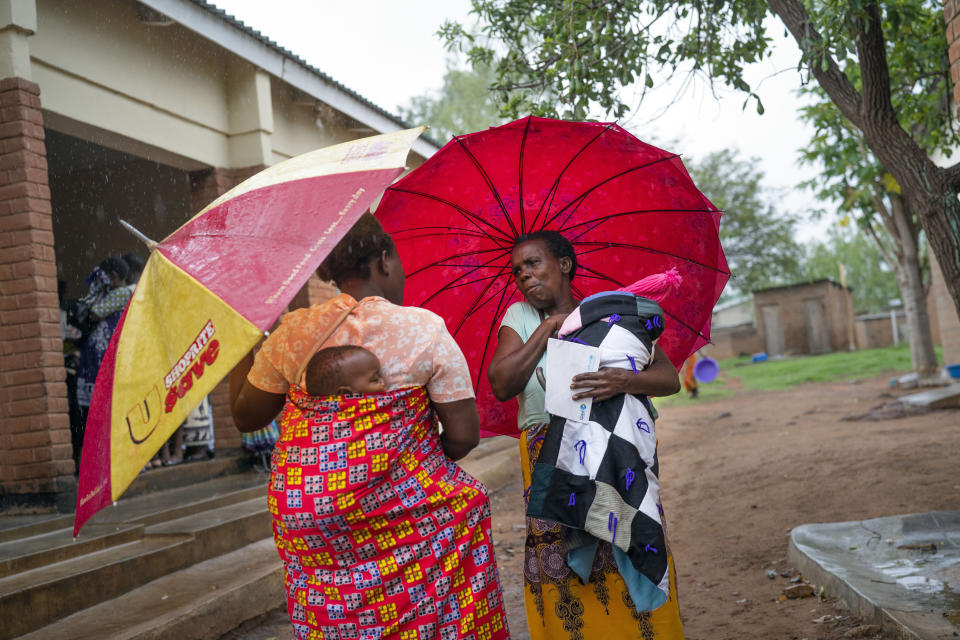 In this photo taken Tuesday Dec. 10, 2019, residents of the Malawi village of Migowi leave after their young children became test subjects for the world's first vaccine against malaria. Babies in three African nations are getting the first and only vaccine for malaria in a pilot program. World health officials want to see how well the vaccine works in Malawi, Ghana and Kenya before recommending its wider use. (AP Photo/Jerome Delay)