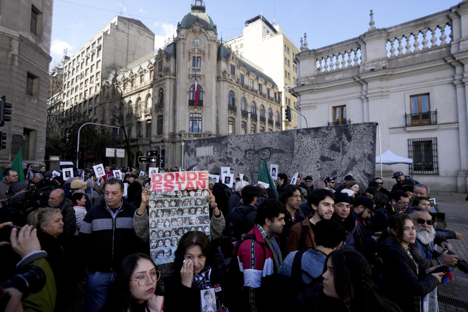 La gente se ubica afuera del palacio presidencial de La Moneda durante una ceremonia que conmemora el 50 aniversario del golpe militar de 1973 que derrocó al gobierno del fallecido presidente Salvador Allende en Santiago, Chile, el lunes 11 de septiembre de 2023. (AP Foto/Esteban Félix)