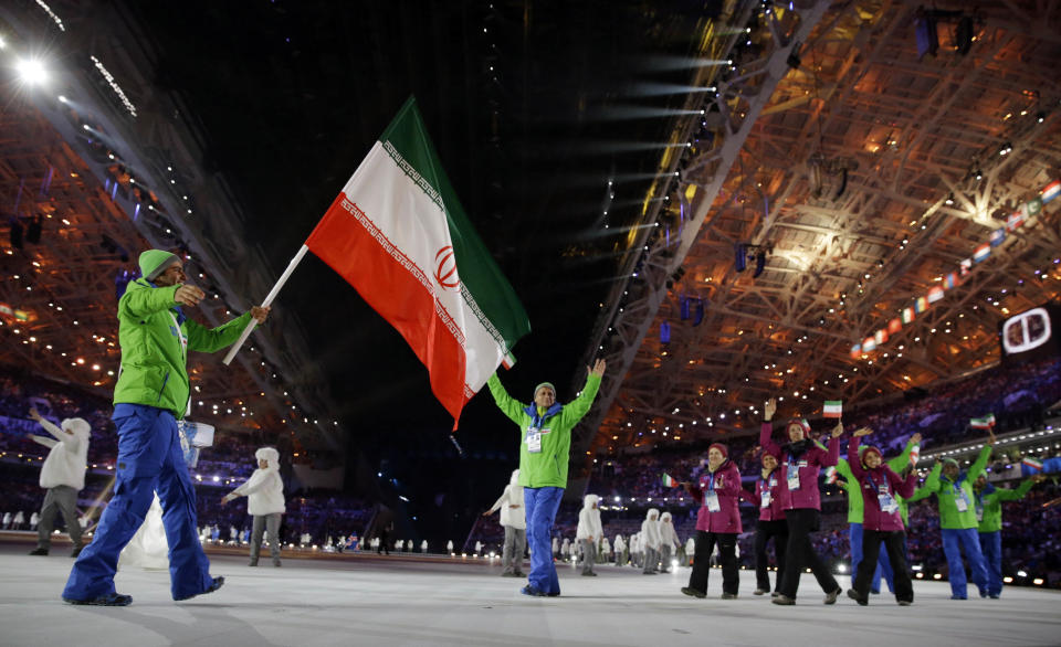 Hossein Saveh Shemshaki of Iran carries the national flag as he leads the team during the opening ceremony of the 2014 Winter Olympics in Sochi, Russia, Friday, Feb. 7, 2014. (AP Photo/Patrick Semansky)