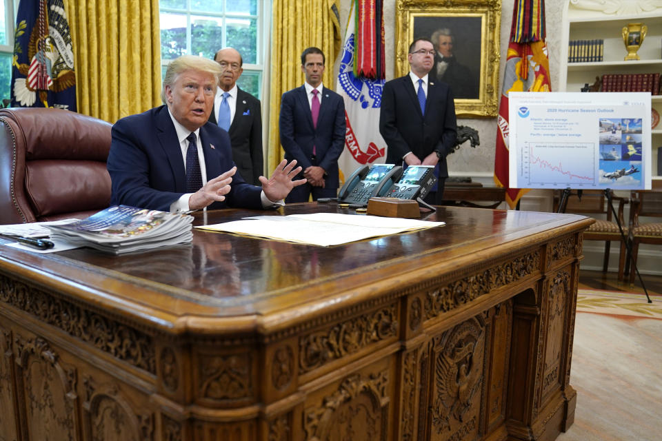 FILE - In this Thursday, May 28, 2020 file photo, President Donald Trump speaks as he receives a briefing on the 2020 hurricane season in the Oval Office of the White House in Washington. Watching are Commerce Secretary Wilbur Ross and Neil Jacobs, assistant Secretary of Commerce for Environmental Observation and Prediction, and Pete Gaynor, administrator of the Federal Emergency Management Agency. A report from the National Academy of Public Administration released on Monday, June 15, 2020 says that NOAA’s acting chief Jacobs and its then-communications director, Julie Kay Roberts, twice breached the agency’s rules designed to protect scientists and their work from political interference, putting out a press statement that “did not follow NOAA’s normal proves and appear to be the result of strong external pressure.” (AP Photo/Evan Vucci)