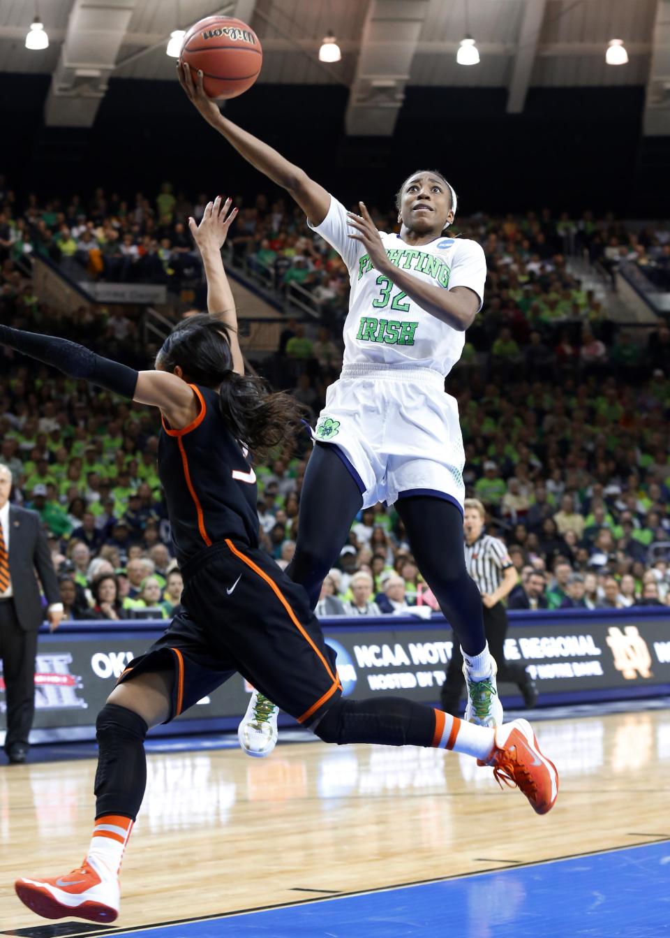 Notre Dame guard Jewell Loyd (32) shoots as Oklahoma State guard Tiffany Bias (3) defends during the first half of a regional semifinal in the NCAA college basketball tournament at the Purcell Pavilion in South Bend, Ind., Saturday, March 29, 2014. (AP Photo/Paul Sancya)