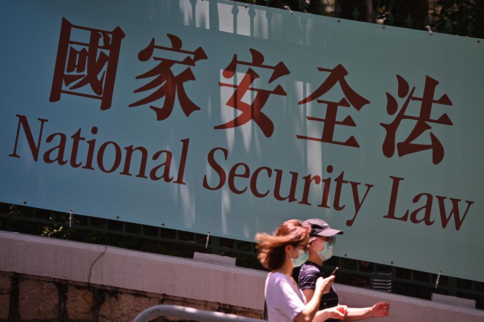 Pedestrians walk past a government public notice banner for the National Security Law in Hong Kong on July 15, 2020. (Photo by Anthony WALLACE / AFP) (Photo by ANTHONY WALLACE/AFP via Getty Images)